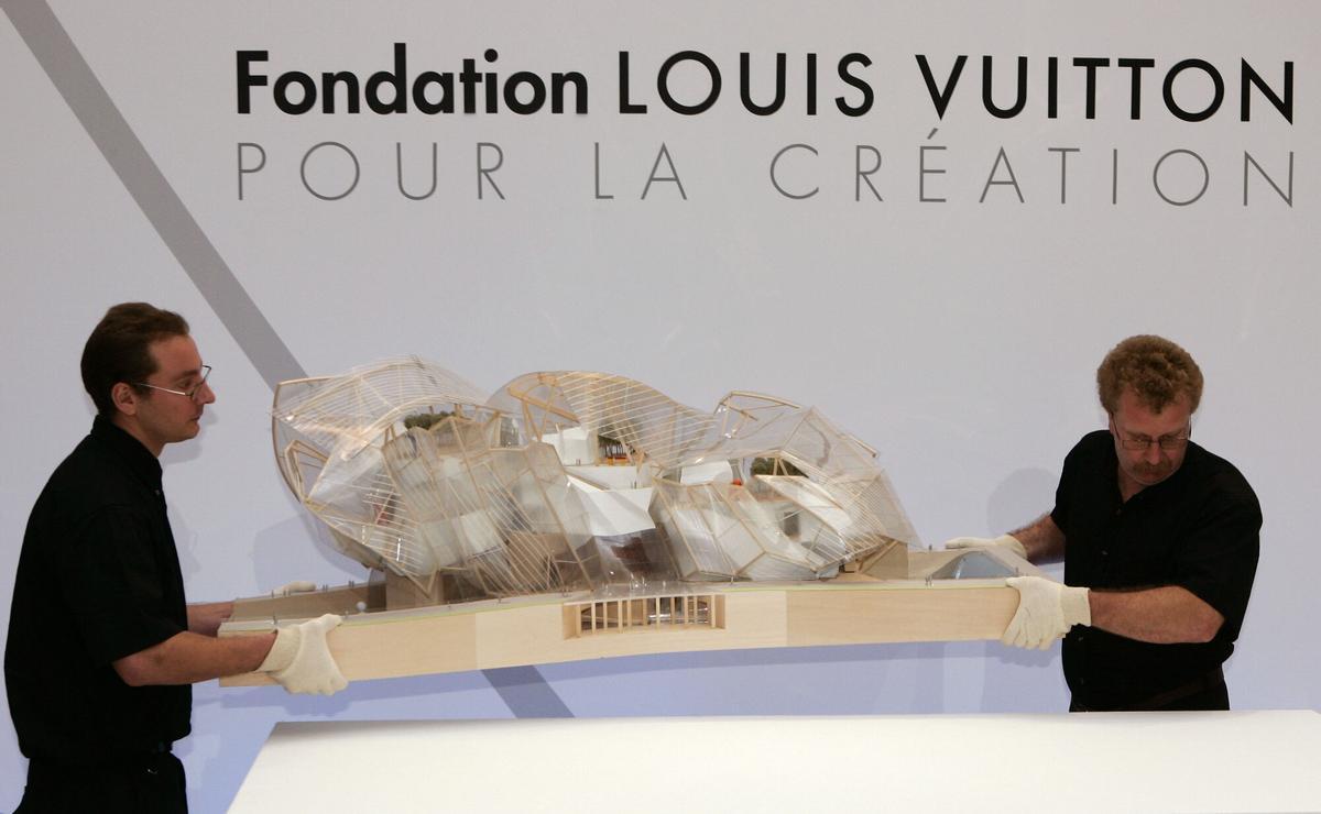 French luxury-goods Moet Hennessy Louis Vuitton (LVMH) employees carry a model of U.S. architect Franck Gehry project during a presentation to announce the birth of the Louis Vuitton Foundation for Creation,  Monday Oct. 2, 2006 in Paris. The Louis Vuitton Foundation for Creation, in line with the 15-year committment of the group to promote culture, heritage and contemporary creation will be sited in the Jardin Dacclimatation in Paris and will be designed by Franck Gehry, author of projects including the famous Guggenheim Museum of Bilbao and the DZ bank Building in Berlin.  (AP Photo/Francois Mori). MUSEOS PARIS , PRESENTACION MAQUETA DISEÑO NUEVO MUSEO COLECCION ARTE DE BERNARD ARNAULT DISEÑADO POR ARQUITECTO  FRANK GEHRY , FUNDACIONES CULTURALES , FUNDACION LOUIS VUITTON LVHM _ PUBLICADA EPC EXIT 03/10/2006 P 70 _ PRESENTACION