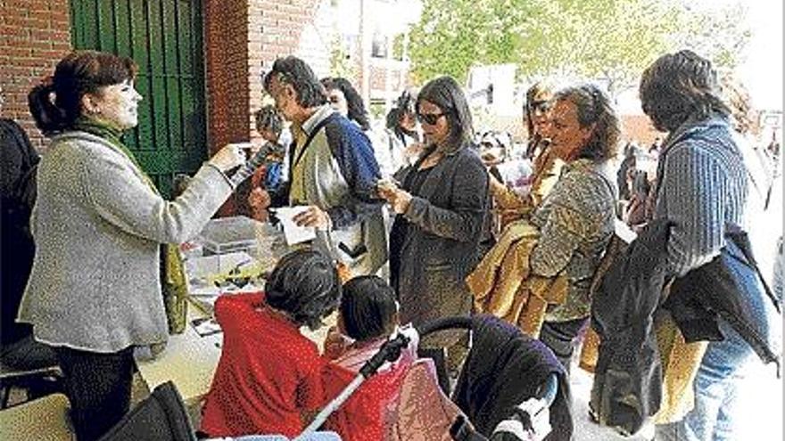 Un grupo de padres, al depositar ayer su voto en el patio del colegio Pare Català de Valencia.