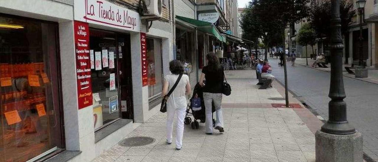 Una calle con tiendas, en Lugones.