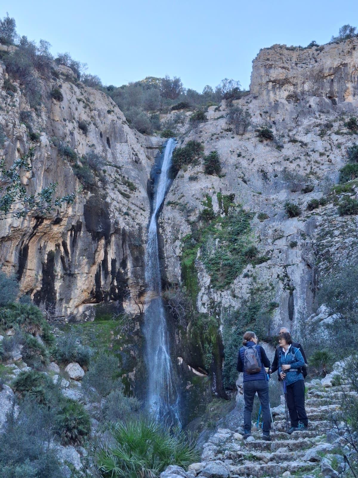 Excursionistas con la cascada al fondo