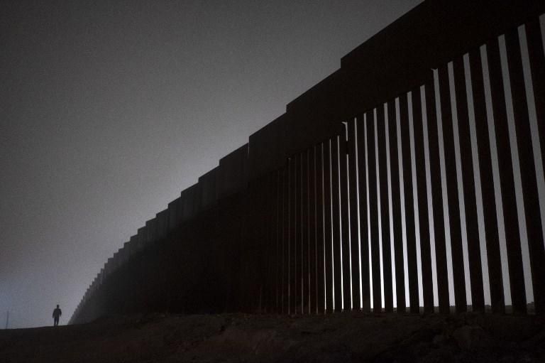 Un hombre camina junto a una sección reforzada de la valla fronteriza que separa EEUU y México en Tijuana, México. 20 de diciembre del 2018. Guillermo Arias / AFP