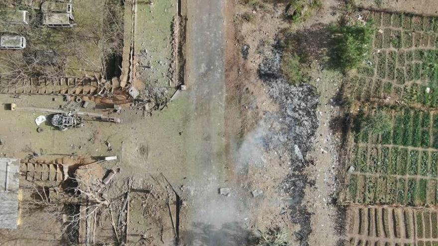 Vista de la zona atacada de la base, con el primer coche detonado en la entrada del recinto. // EMAD