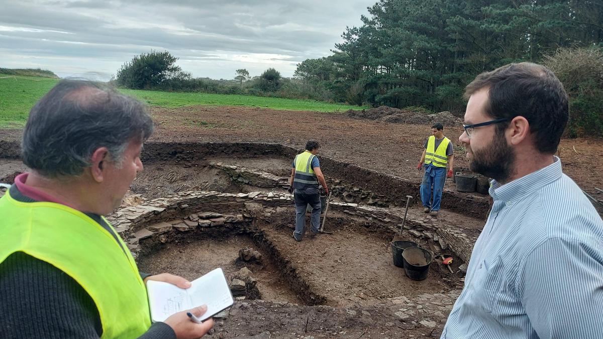 El alcalde de Tapia (a la derecha) conversa con el arqueólogo Alfonso Menéndez en la excavación del año pasado.