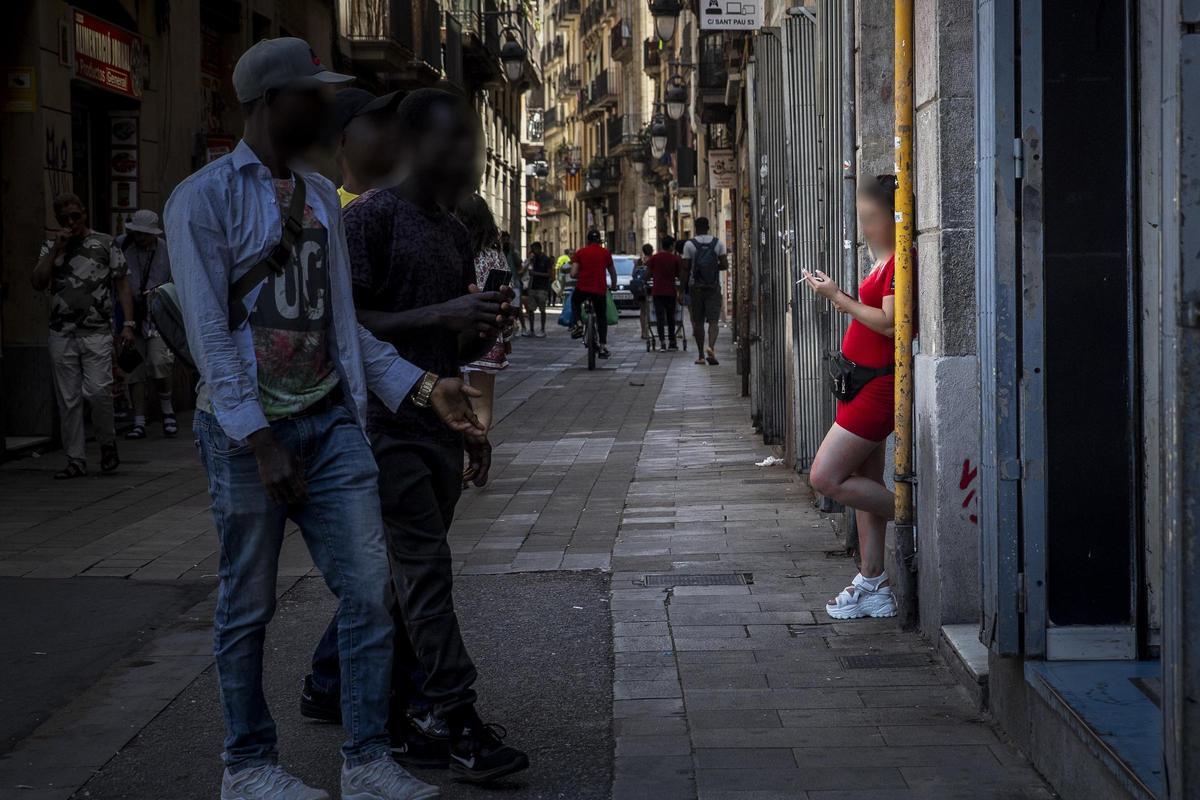 Una prostituta esperando a clientes en un portal de la calle Robadors, en el barrio del Raval, en Barcelona. Una prostituta esperando a clientes en un portal de la calle Robadors, en el barrio del Raval, en Barcelona.