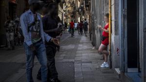 Una prostituta esperando a clientes en un portal de la calle Robadors, en el barrio del Raval, en Barcelona.
