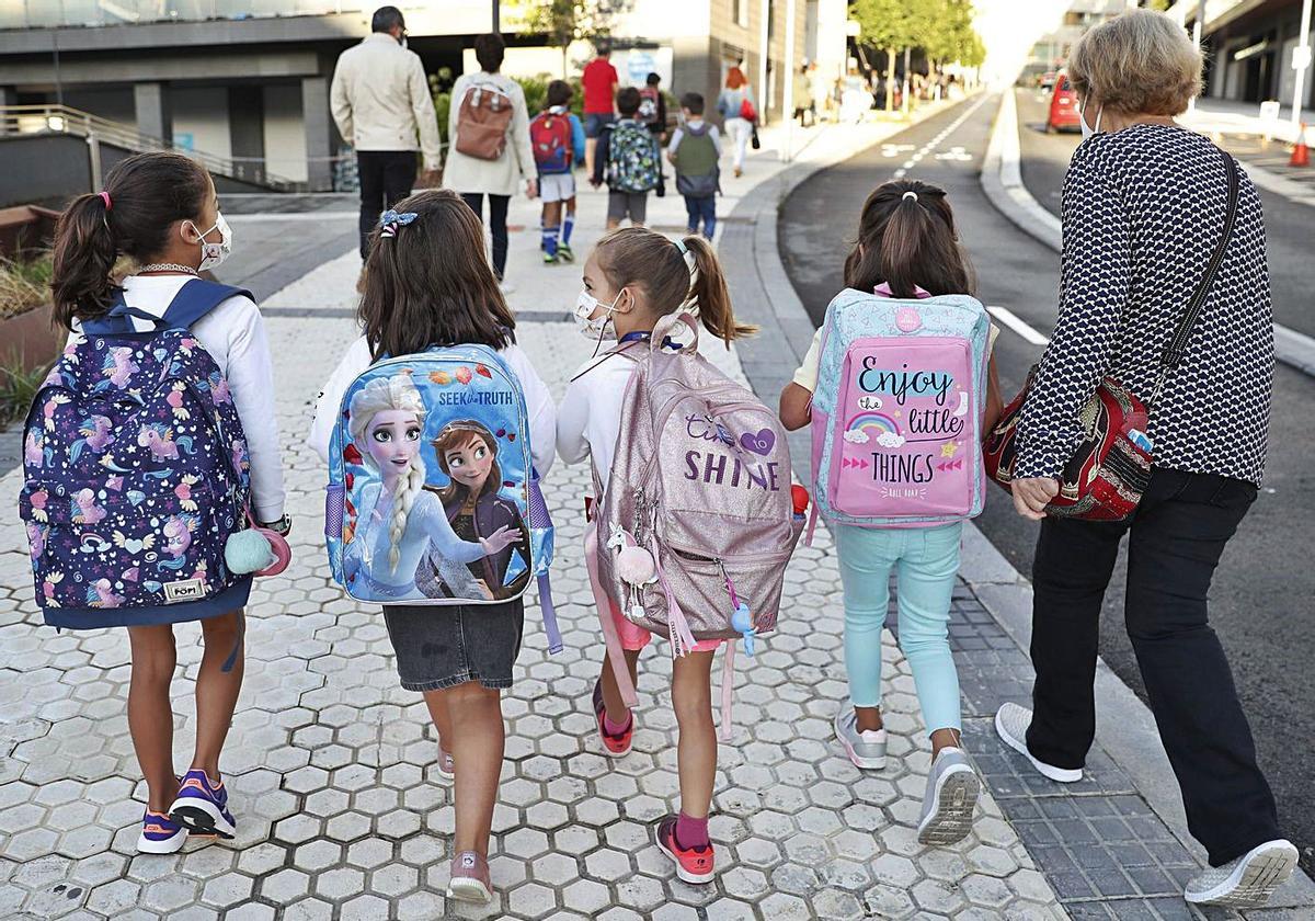 Niñas acudiendo al colegio con mascarilla.
