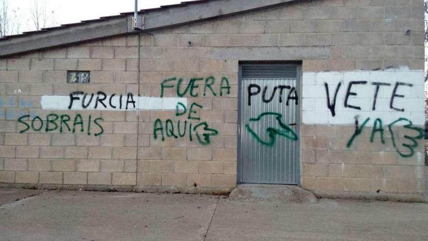 Pintadas con insultos y amenazas aparecidas en la zona de recreo de la playa de Rionegro del Puente.