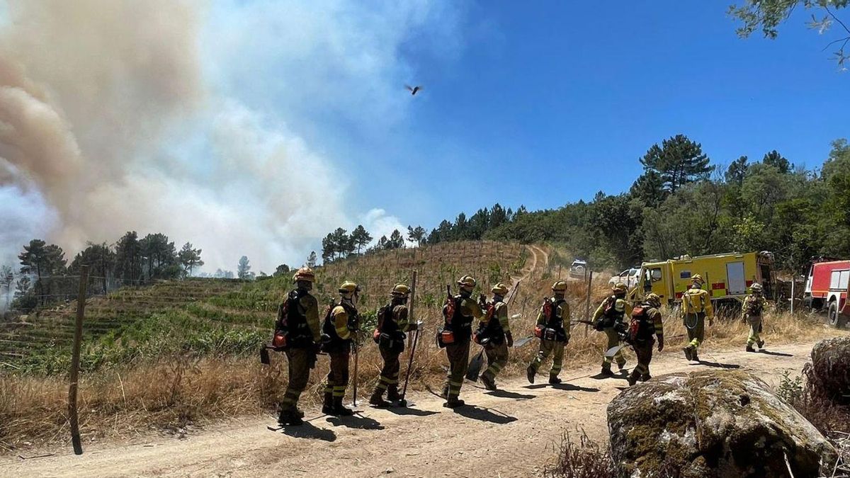 Bomberos forestales y medios aéreos, trabajando este martes por la tarde en la extinción en Carballeda de Avia. |  A. Ferro