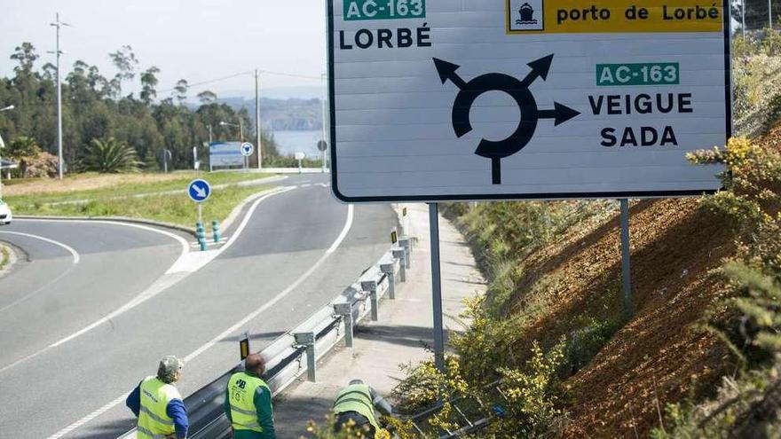 Obreros ayer, tras quitar la cinta que tapaba el nombre del puerto de Lorbé.