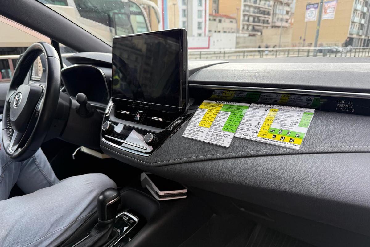 Un taxista amb les tarifes al seu cotxe