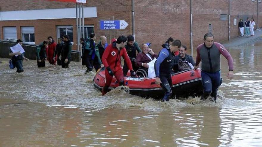 Los bomberos rescatan a un paciente del Hospital de Arriondas, tras la inundación de junio de 2010.