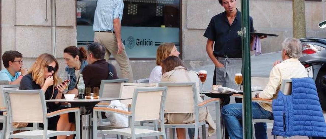 Una camarera atiende una terraza de Vigo durante el verano.  // Marta G. Brea