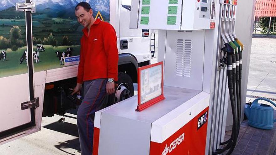 El empleado de una gasolinera llena el depósito de un camión de mercancías.