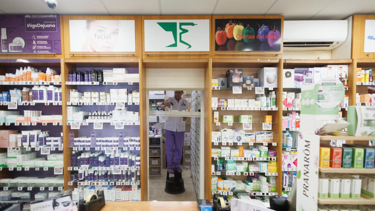 Farmacéuticos y clientes sin mascarilla en una farmacia del distrito de Carabanchel, en Madrid