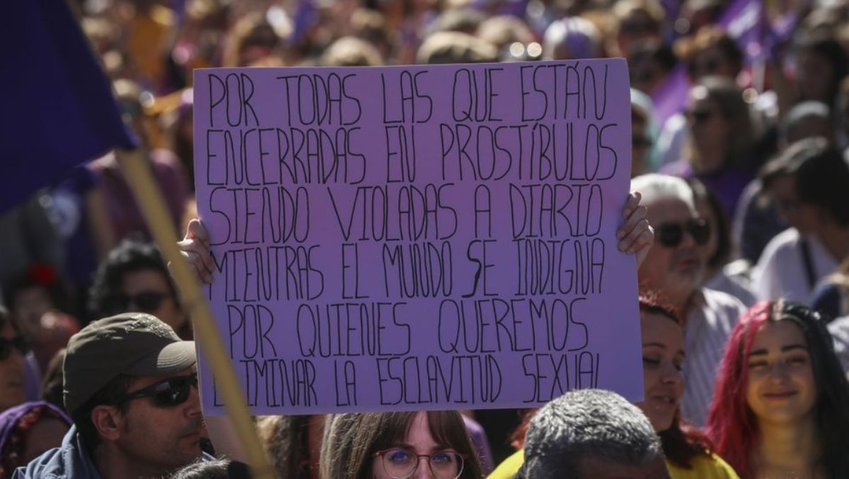 Una mujer sostiene su pancarta con un mensaje de protesta en contra de la prostitución durante la manifestación del 8M de 2020.