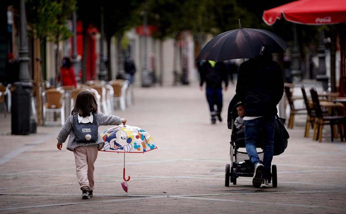 Una niña y su padre caminan  por una calle peatonal en Fuenlabrada.