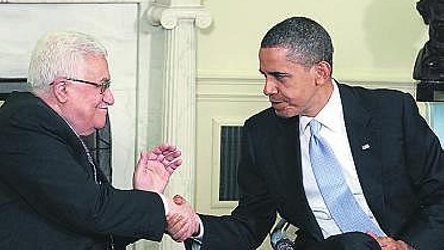 Abbas estrecha la mano de un Obama con rostro de preocupación.