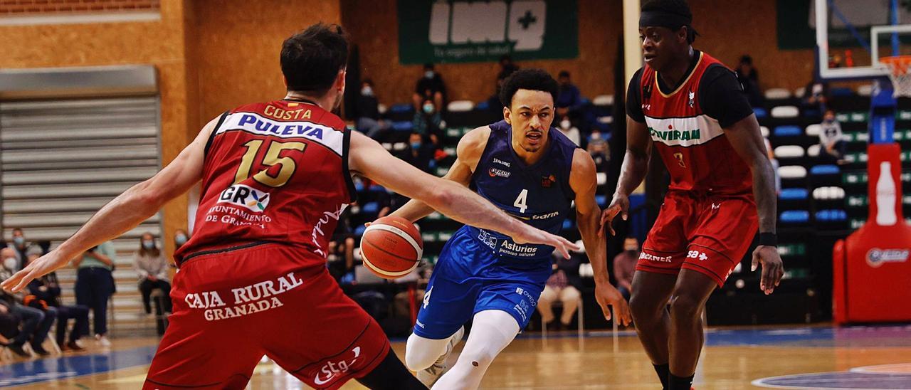 Elijah Brown supera a Thomas Bropleh y encara a Lluís Costa, ayer, en el polideportivo de Pumarín. |