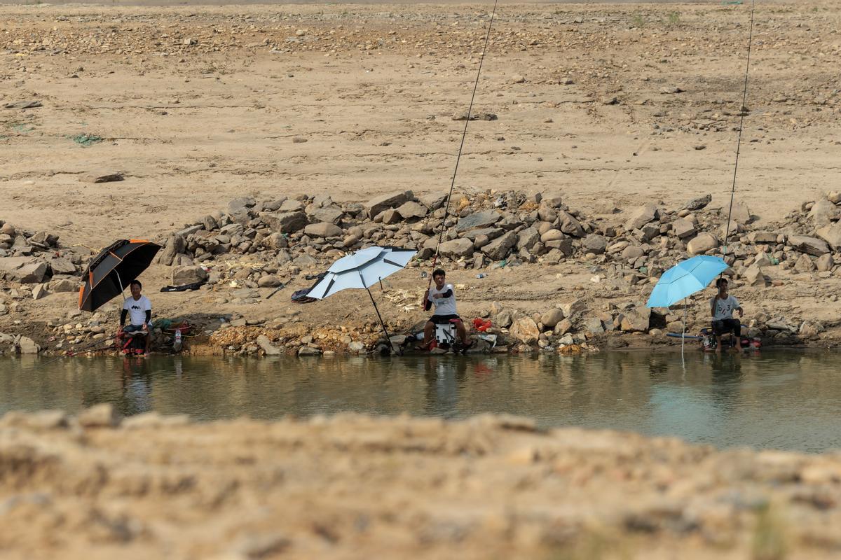 Pescadores en un charco del lecho seco del río.