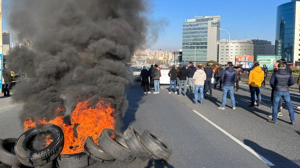 Neumáticos en llamas en mitad de Alfonso Molina, durante la protesta de la plantilla de Alu Ibérica. |   // L.O.