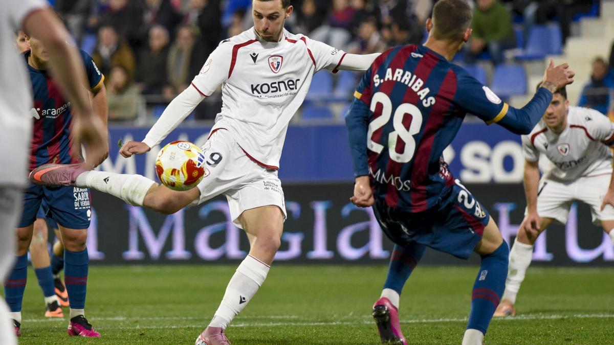 HUESCA, 17/12/2025.- El delantero de Osasuna Raúl García (i) se dispone a chutar para marcar ante el Huesca, durante el partido de dieciseisavos de final de la Copa del Rey que SD Huesca y CA Osasuna disputan este miércoles en el estadio de El Alcoraz. EFE/Javier Blasco
