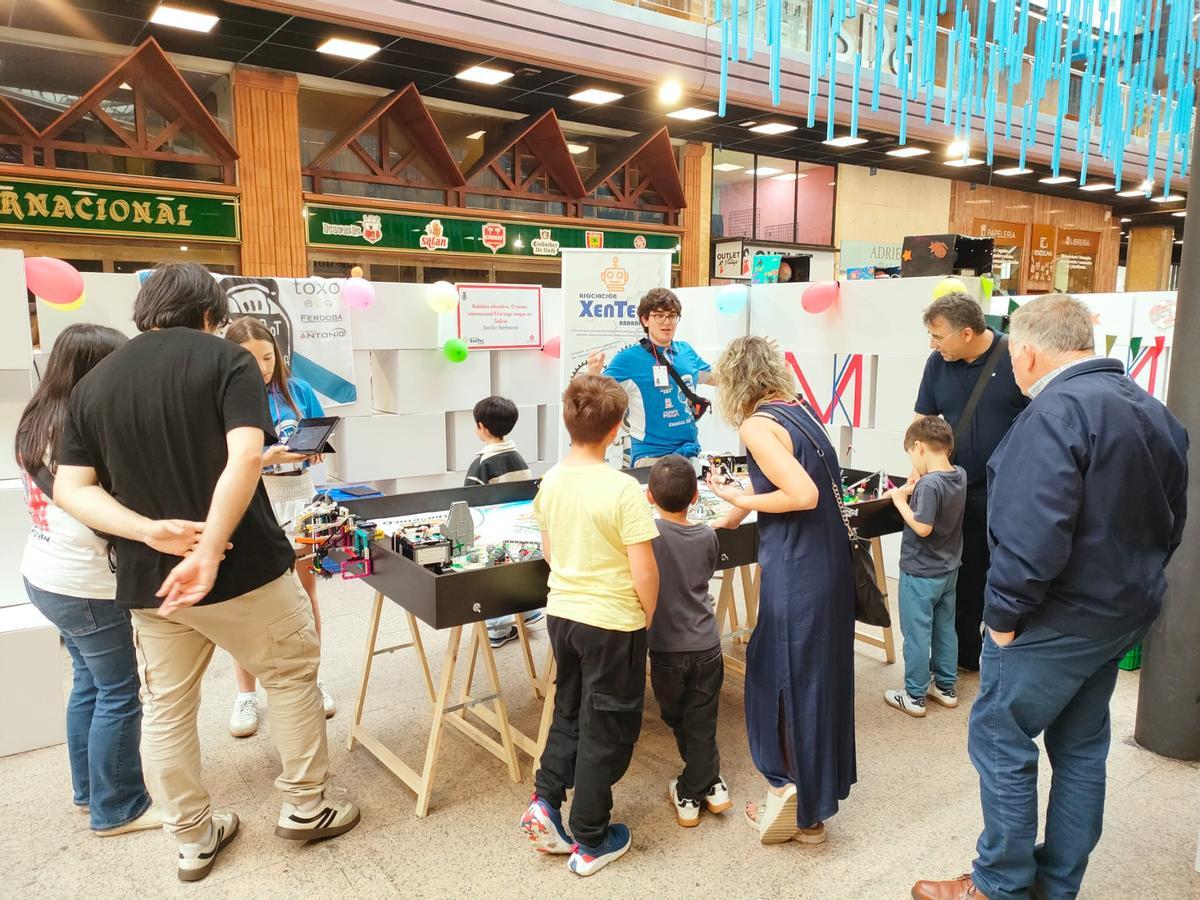 Varias persoas interesándose por as pezas expostas nun dos stands en Área Central.