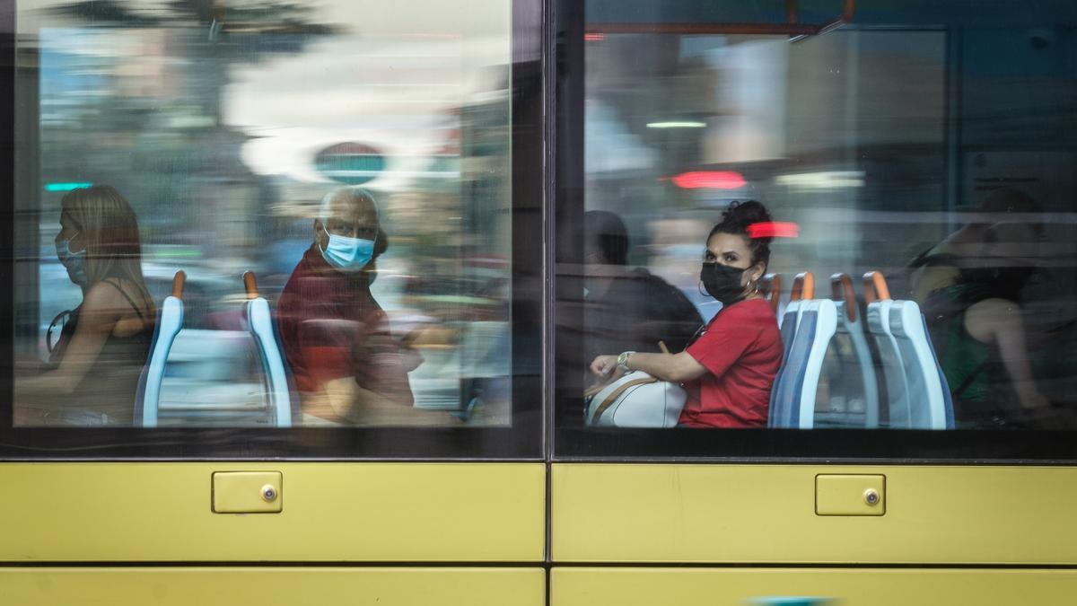 Pasajeros con mascarilla en el tranvía.