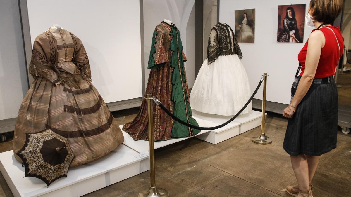 Una visitante al museo recorre la exposición de moda del Siglo de Oro.