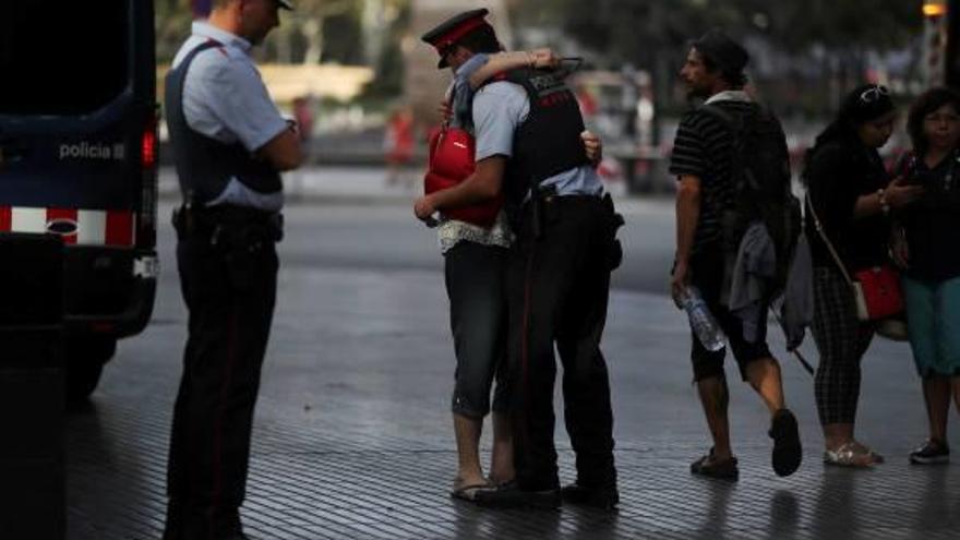 Una dona abraça un mosso d&#039;esquadra a la Rambla de Barcelona.