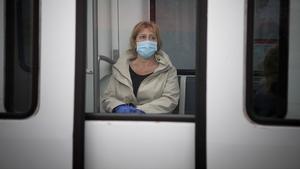 España obliga a usar mascarillas en el transporte público. En la foto, una mujer se protege en el metro de Barcelona.
