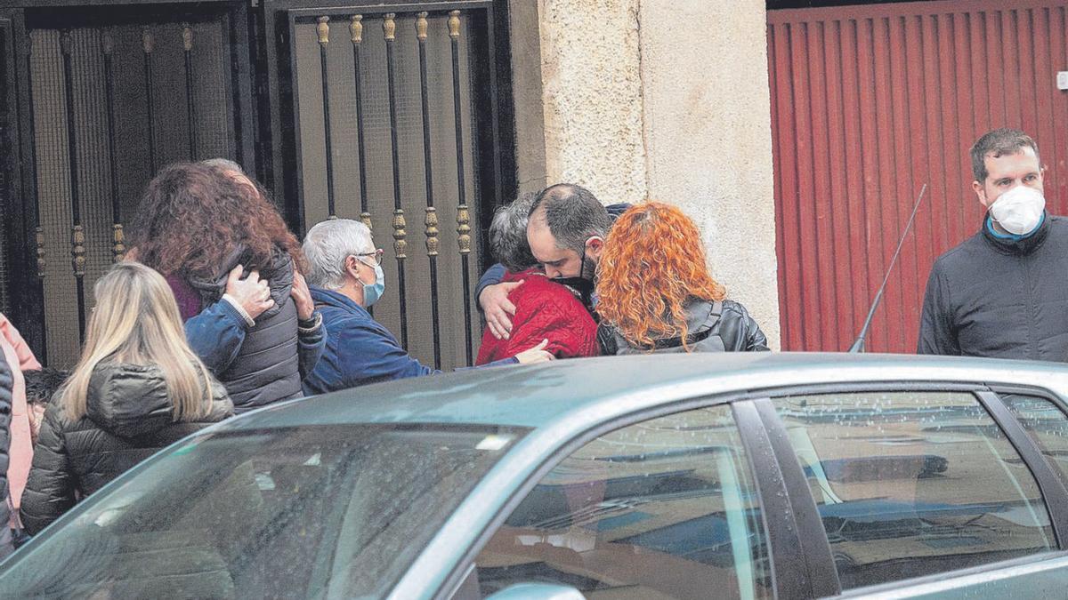 Los familiares de la víctima se abrazan frente a la vivienda de la pareja. | TONY SEVILLA