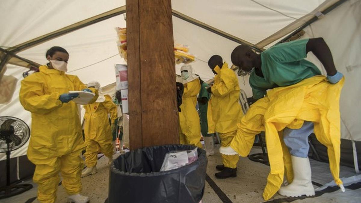 Personal de Médicos sin Fronteras se pone trajes protectores, en un centro sanitario de Kailahun, en Sierra Leona.