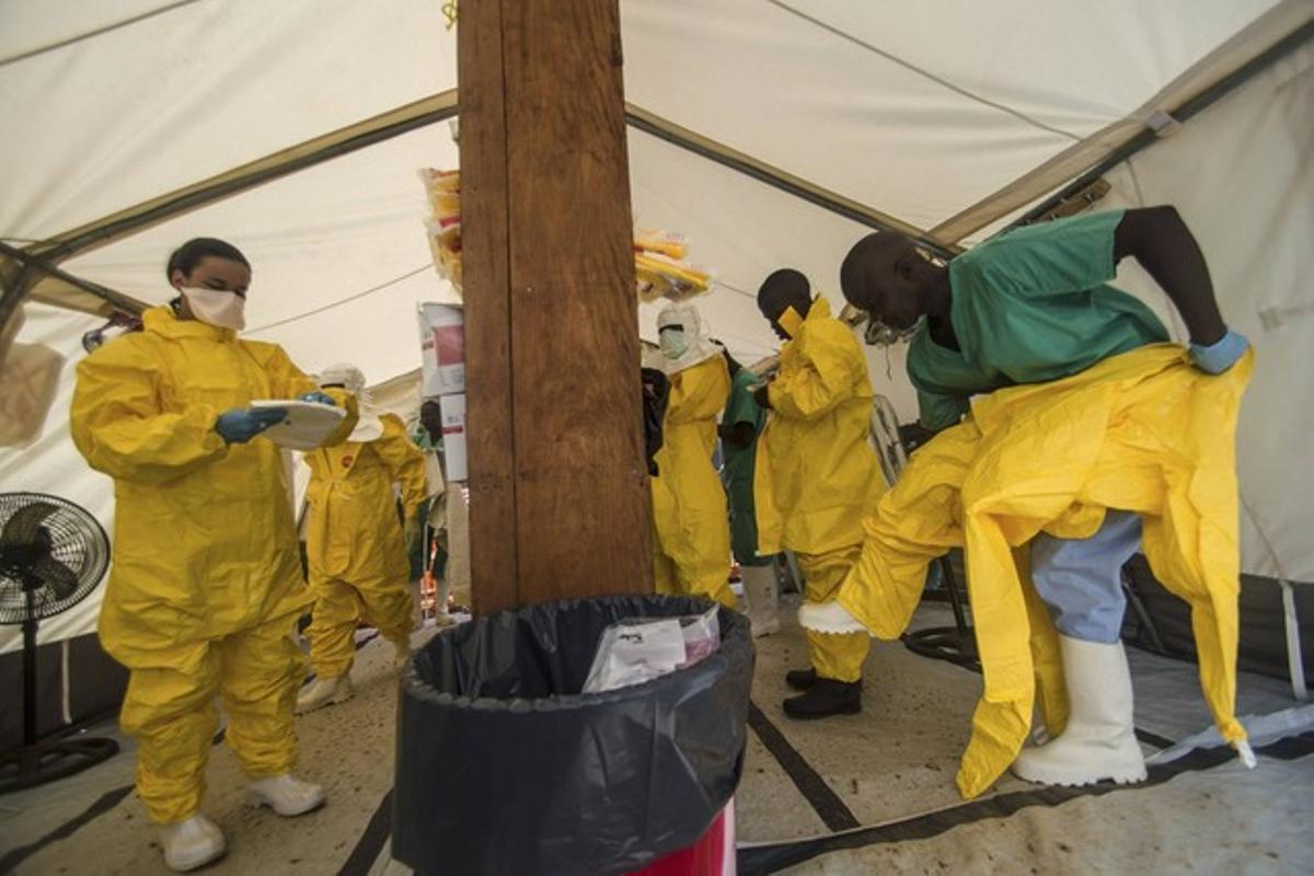 Personal de Metges sense Fronteres es posa equips protectors, en un centre sanitari de Kailahun, a Sierra Leone.