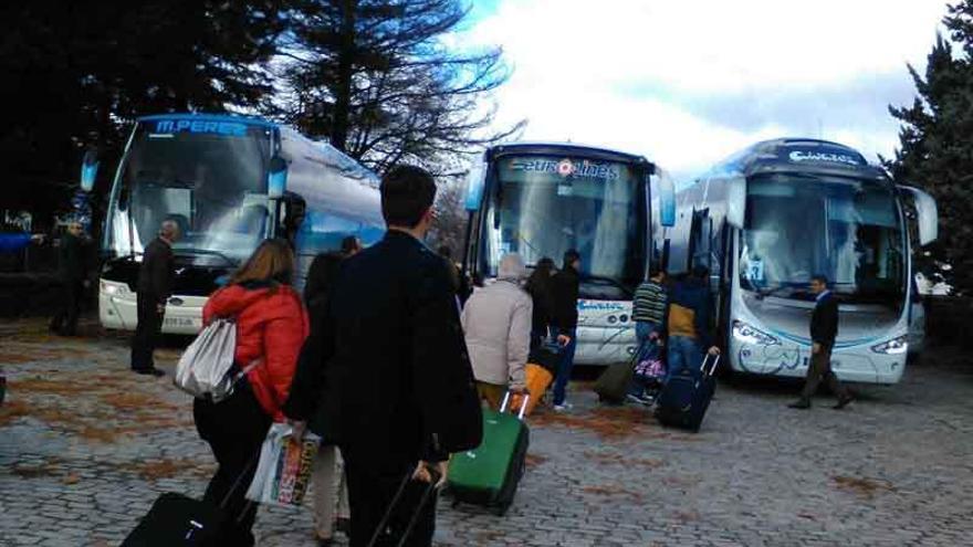 Los viajeros procedentes de Galicia junto a los autobuses que los trasladaron a Puebla de Sanabria, en cuya estación aparecen sobre estas líneas para esperar al tren.