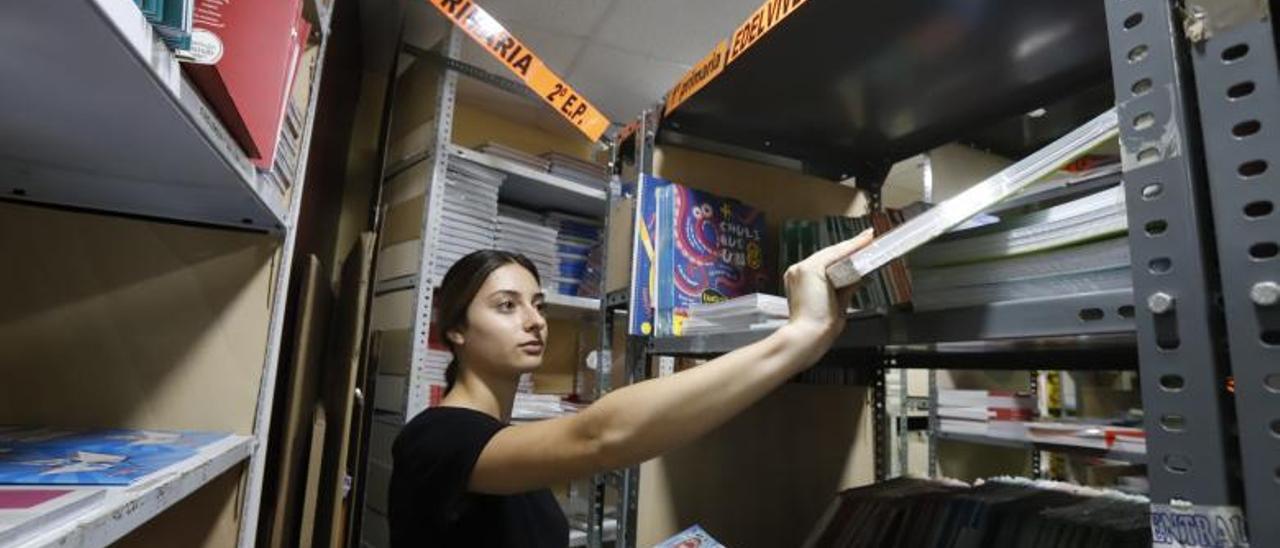 Una dependienta de la Librería Central, en Zaragoza, coge varios libros de texto del almacén, ayer.