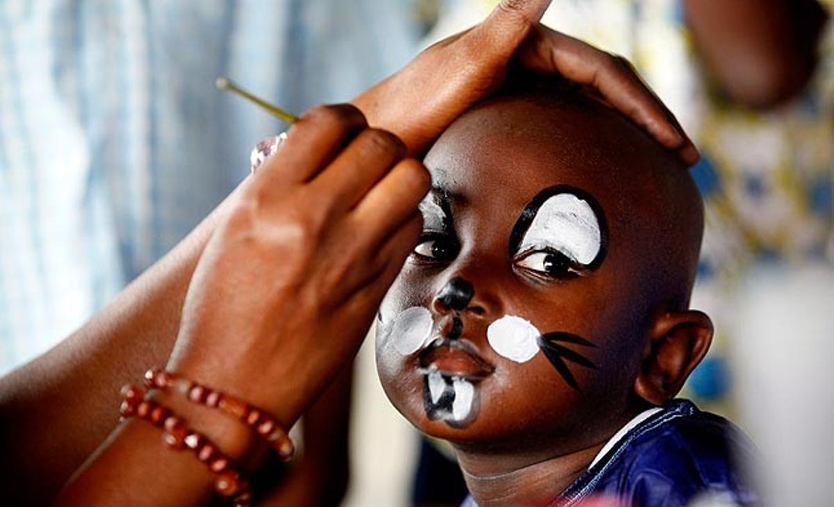 Una dona pinta aquest dijous una nena d’Abdidjan (capital de la Costa d’Ivori) en el Dia del Nen Africà. Aquest dia commemora les revoltes sud-africanes del 1976 a les escoles de la població de Soweto (a prop de Johannesburg), que va ser un episodi clau en la lluita contra l’’apartheid’.