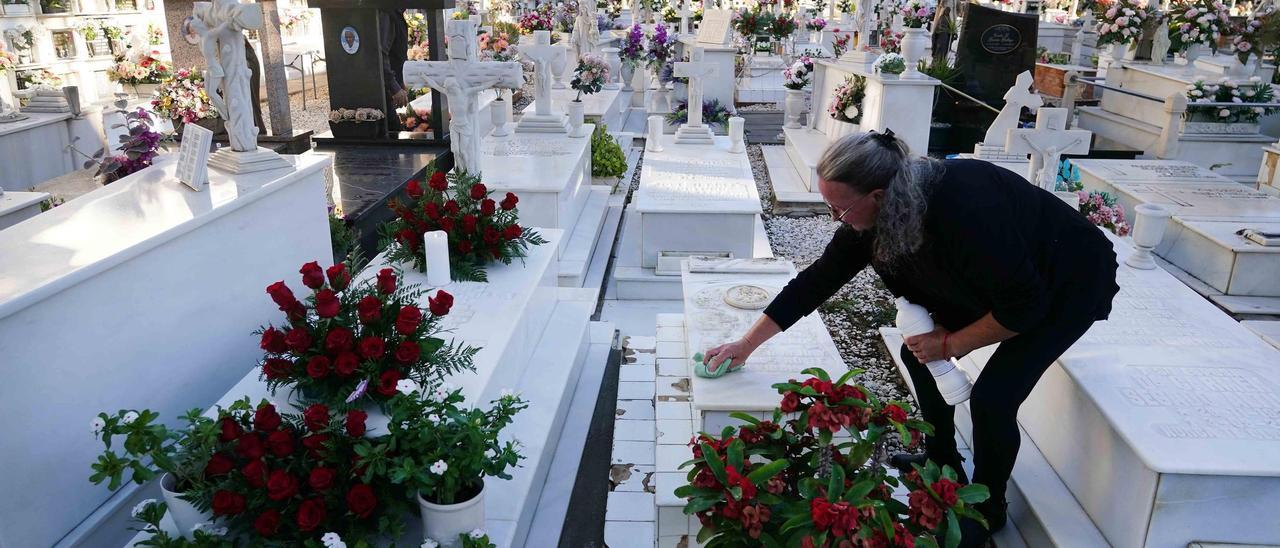 Una mujer limpiaba este miércoles una tumba en el Cementerio de San Juan, en El Palo.