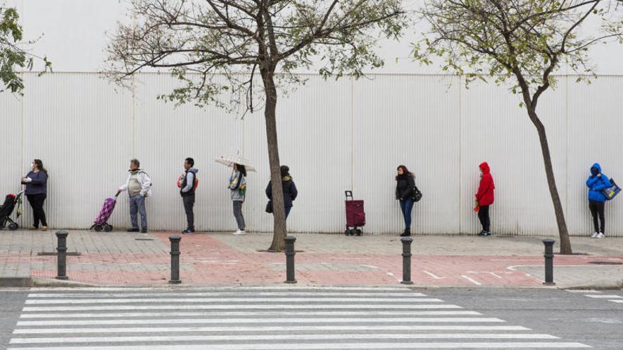 Personas haciendo cola para entrar en un supermercado de Alicante