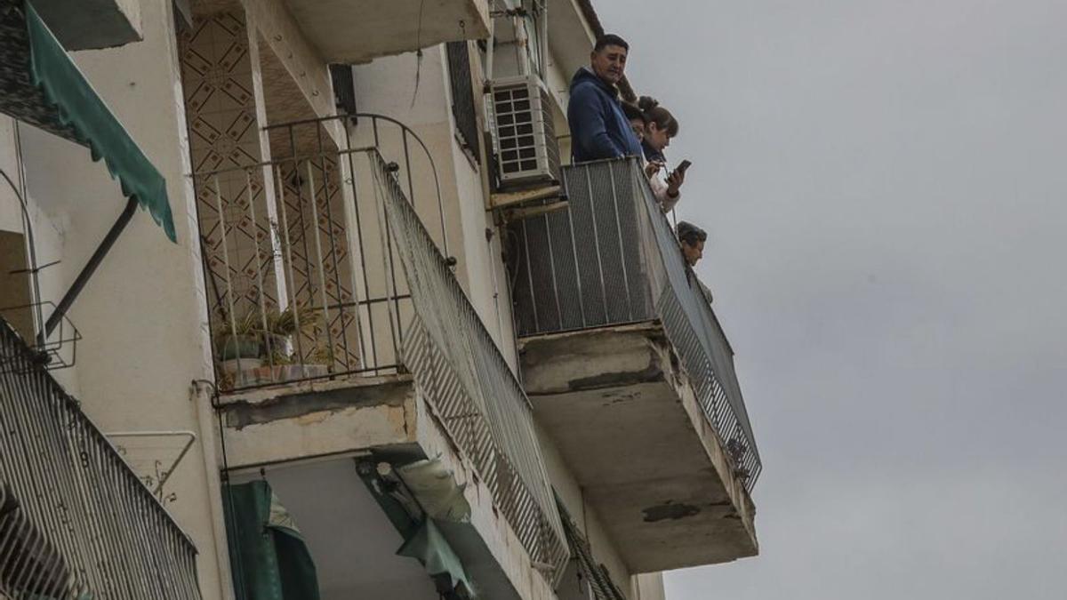 Vecinos asomados desde sus deteriorados balcones.