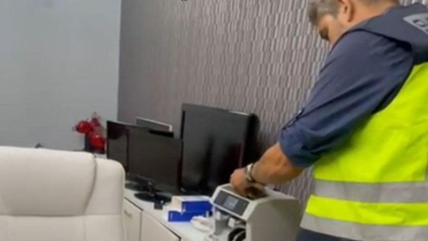 Uno de los agentes participantes en la operación cuenta los billetes. |