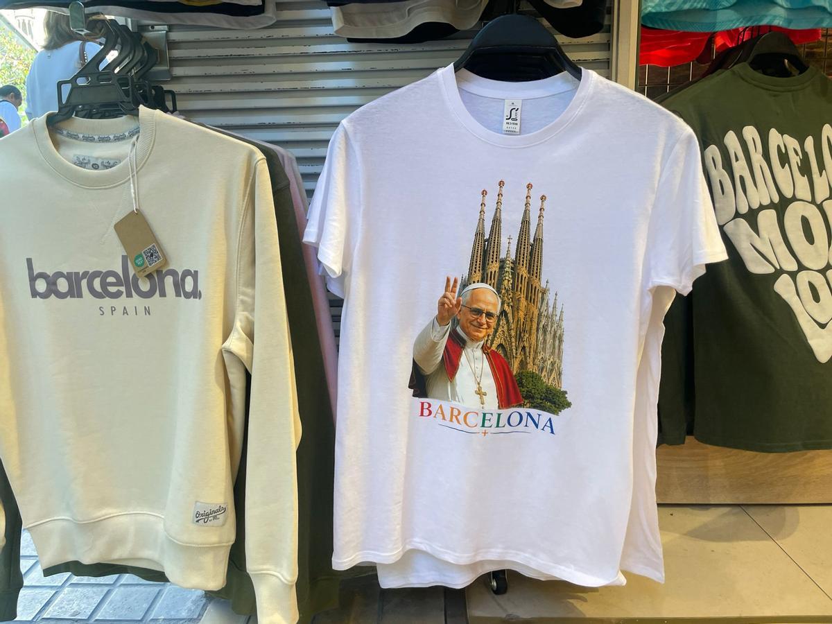 Una camiseta con un montaje del Papa en la Sagrada Família, en la tienda de souvenirs 'I am Barcelona'