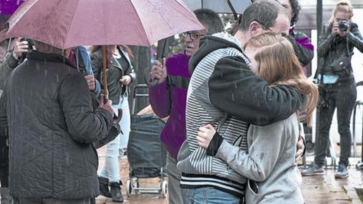 Dolor bajo la lluvia 3 Un padre abraza a su hija tras el homenaje en el IES Giola, ayer por la mañana.