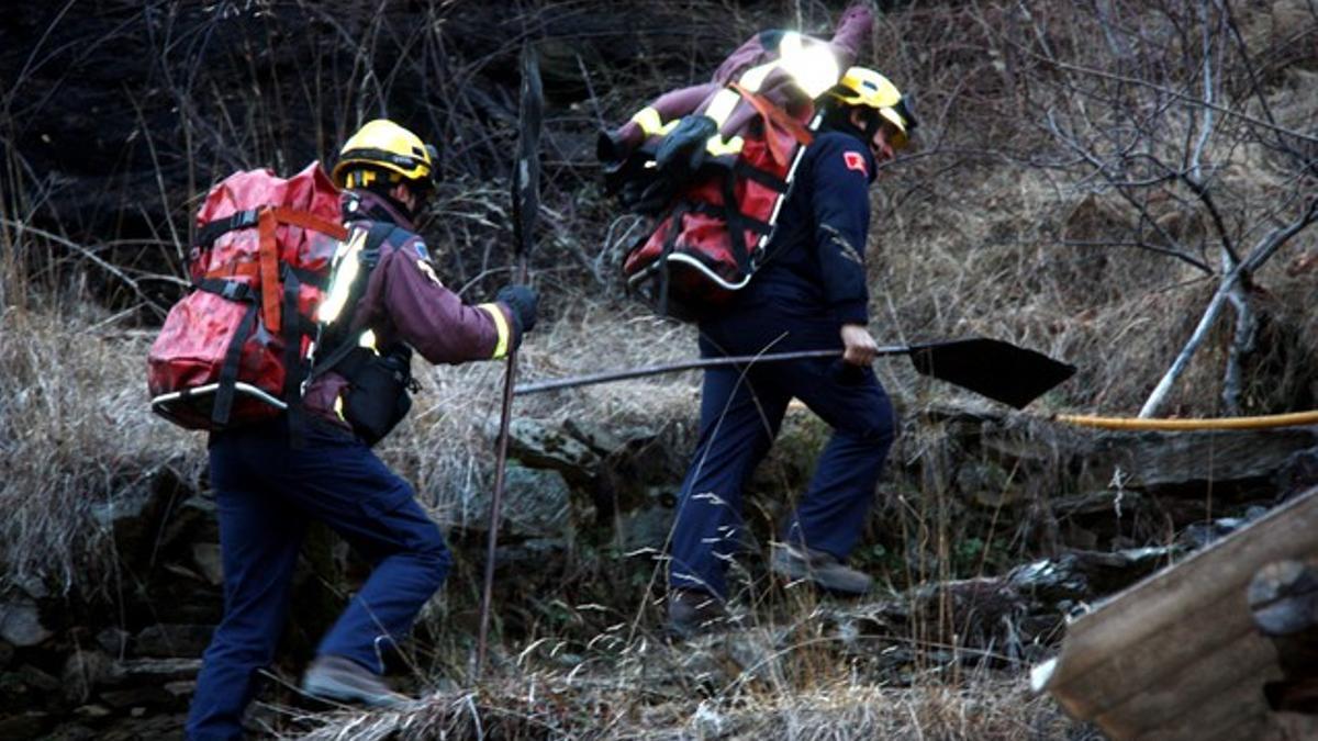 Dos bomberos se dirigen, ayer lunes, a la zona del incendio en la Vall Fosca.