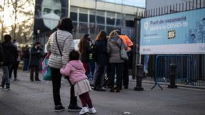 Una madre junto a su hija frente al centro de vacunación de Fira de Barcelona.