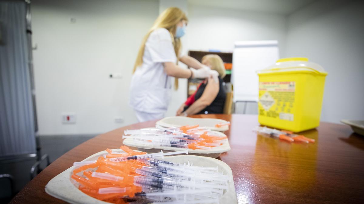 Una enfermera vacuna a una vecina de Zaragoza, en el centro de salud Actur Oeste.