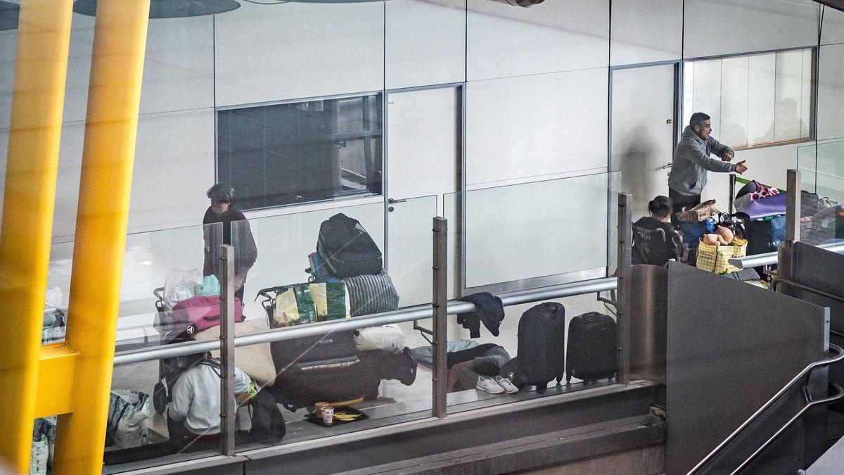 Personas sin hogar, durmiendo en uno de los pasillos de la T-4 del aeropuerto Madrid Barajas.