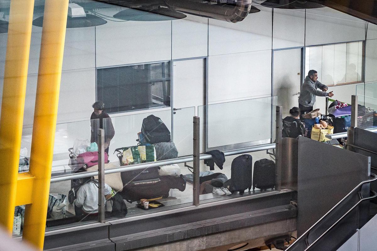 Personas sin hogar, durmiendo en uno de los pasillos de la T-4 del aeropuerto Madrid Barajas.