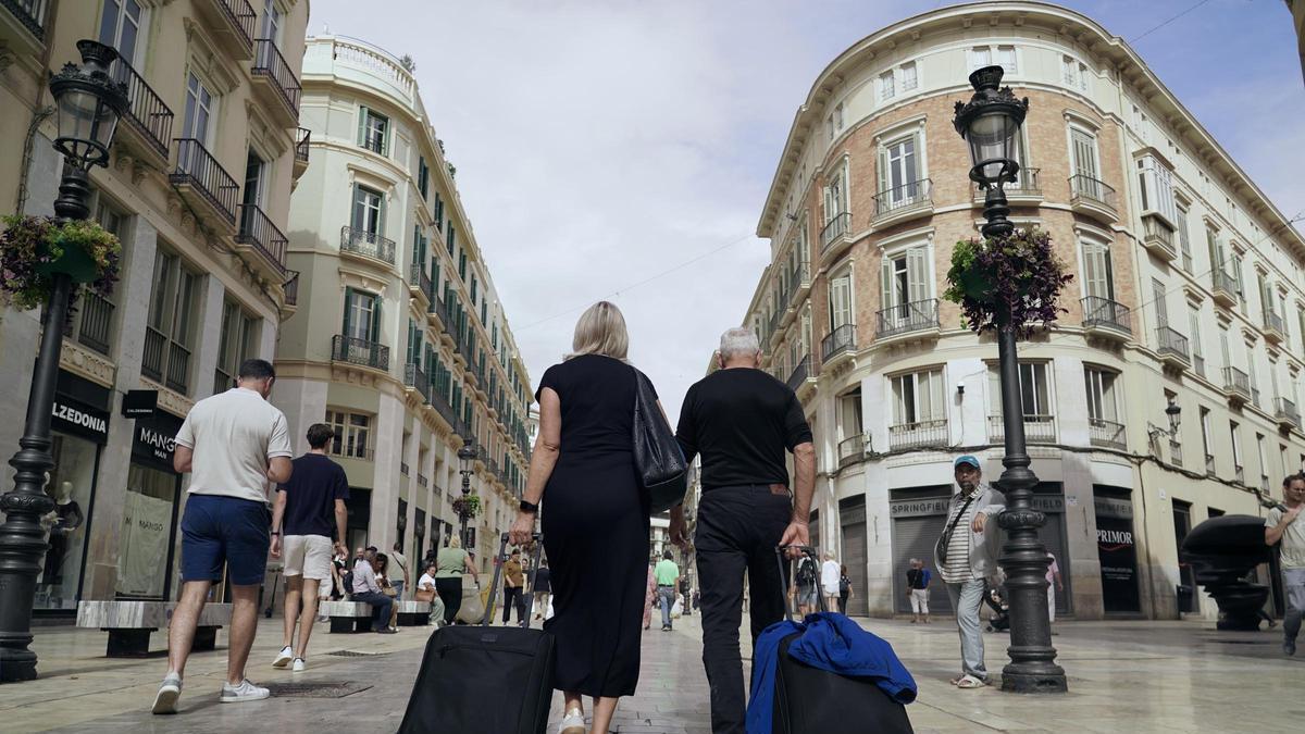 Turistas con sus maletas en el Centro de Málaga.