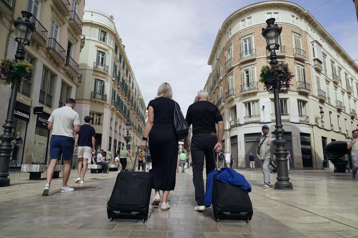 Turistas con sus maletas en el Centro de Málaga.