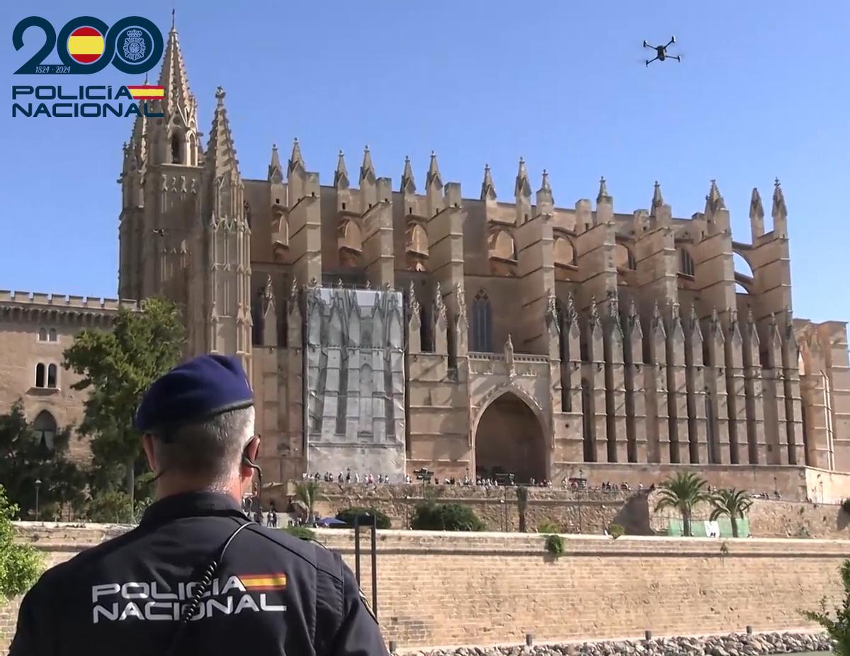Un policía vuela un dron frente a la Catedral de Mallorca.